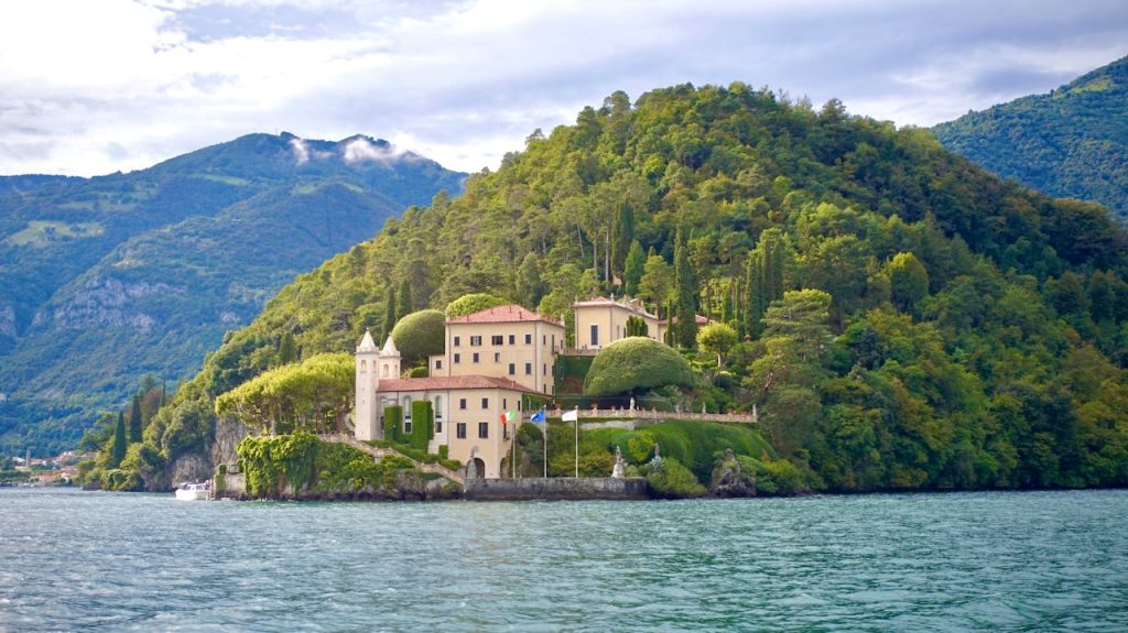 Scenic view of Villa del Balbianello nestled on Lake Como surrounded by lush greenery.